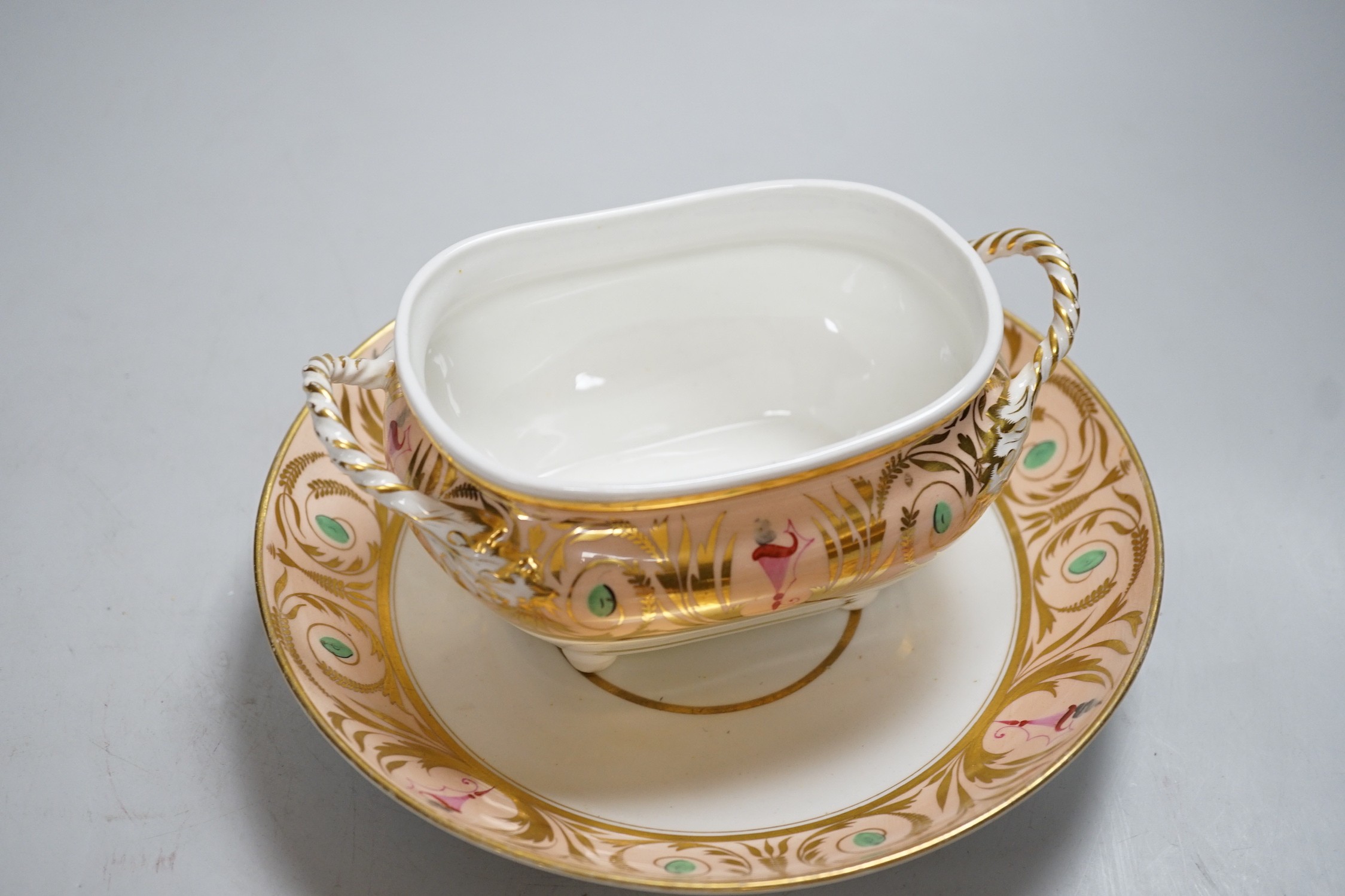 A 19th century Derby sucrier and cover and a matching saucer dish decorated in neo-classical style on a salmon coloured ground, red mark. 15cm tall overall